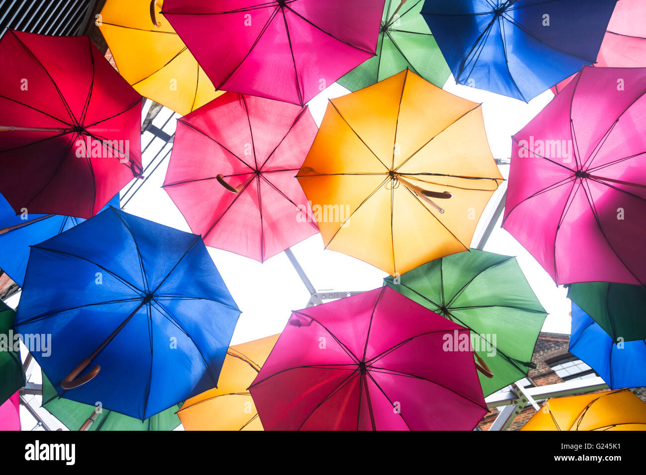 Auf der Suche bis zu mehrfarbig Sonnenschirme unterbrochen von einem Glasdach, London, England. Stockfoto