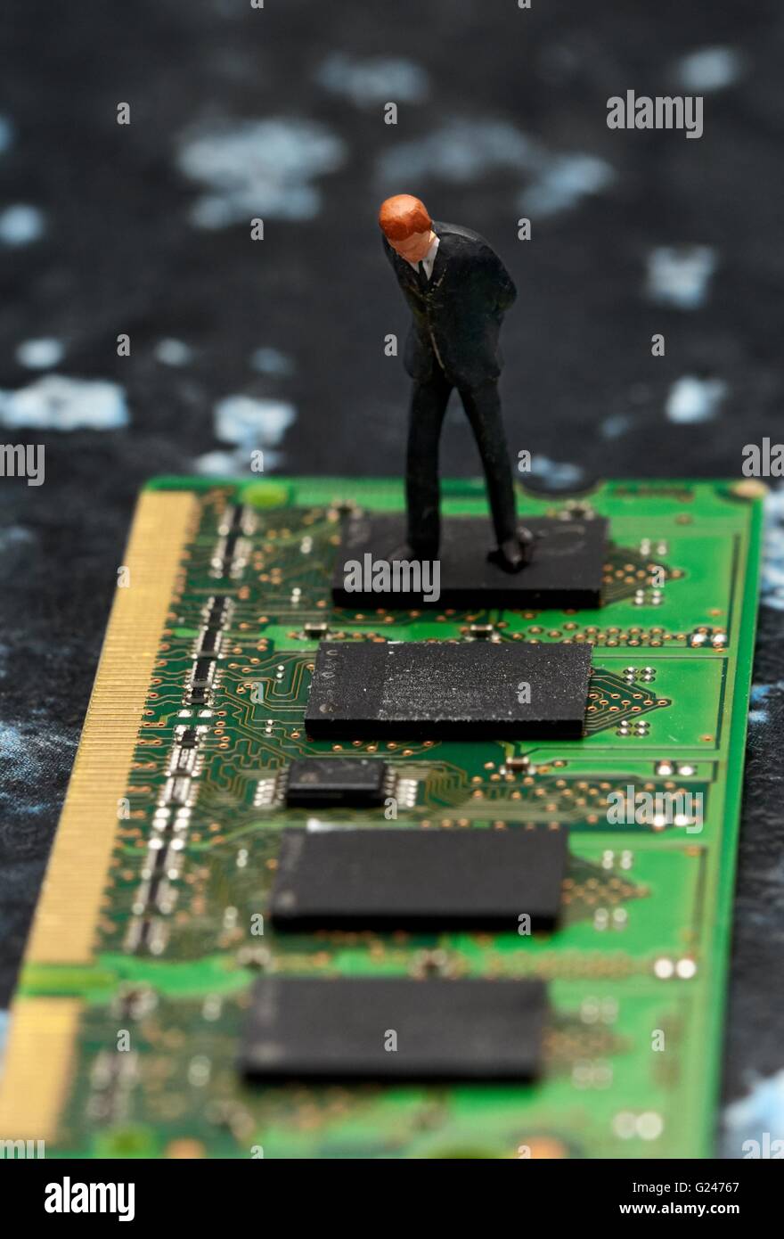 Eine Miniatur Figur Geschäftsmann Blick hinunter auf Computer-Chip-Speicher. Stockfoto