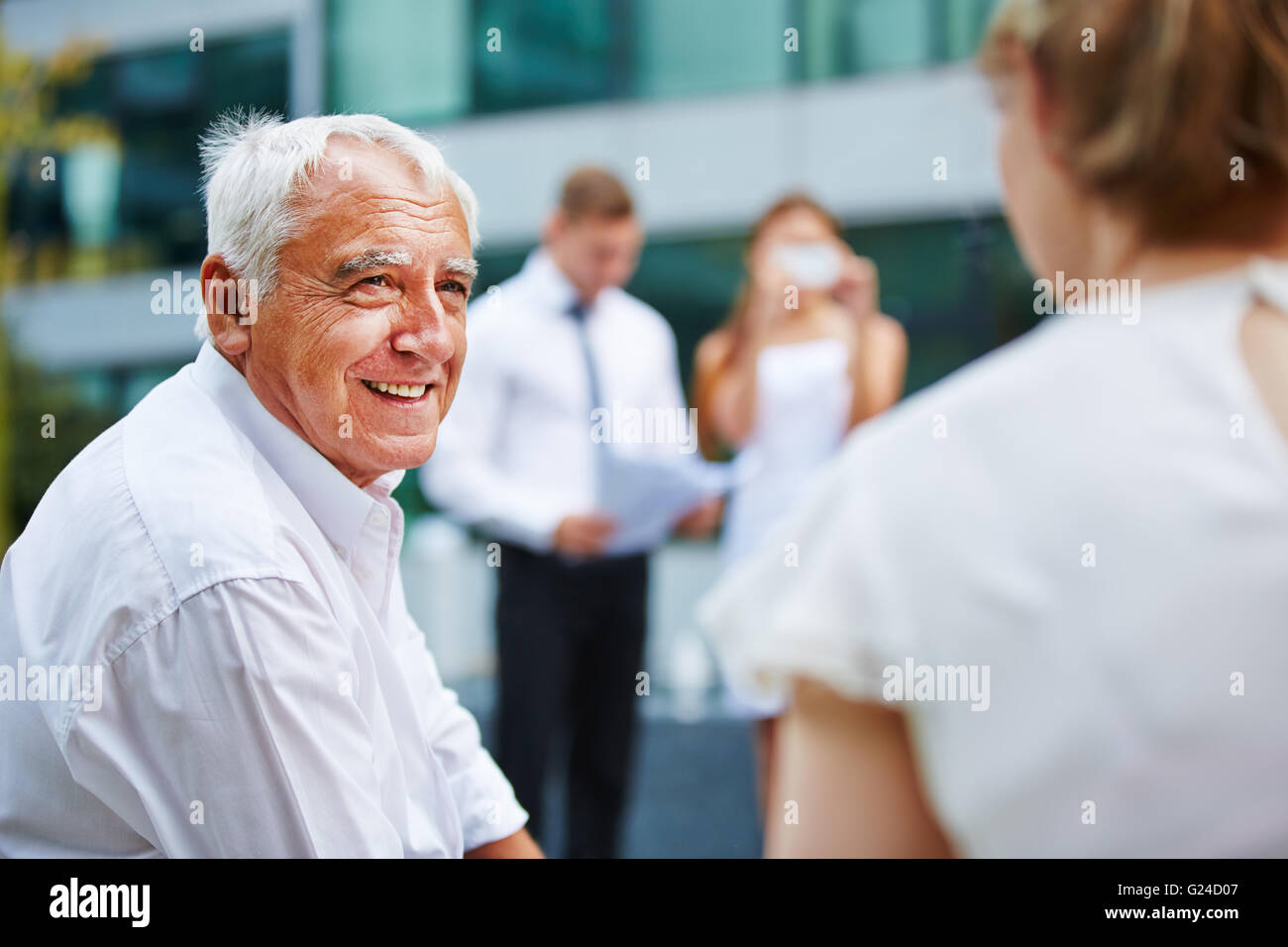 Alten Geschäftsmann im Gespräch mit Business-Team während der Verhandlungen im freien Stockfoto