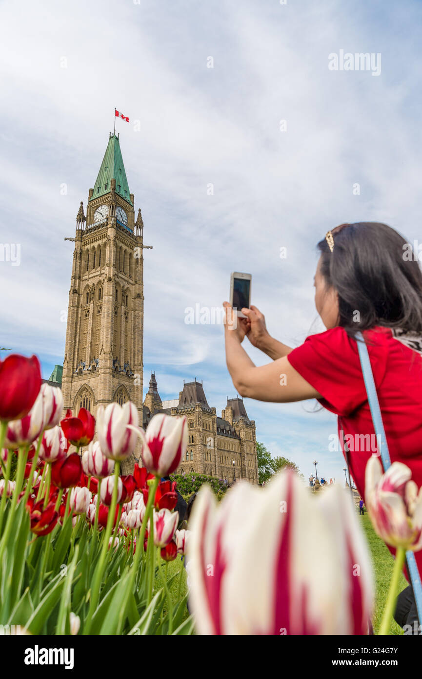 Asiatische Frau die Bilder von dem kanadischen Parlament Centre Block in Ottawa Stockfoto