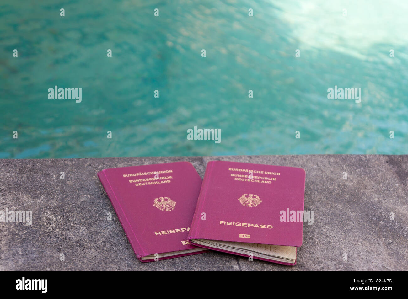 Zwei deutsche Pässe vor türkisfarbenem Wasser. Urlaubs-Feeling. Stockfoto