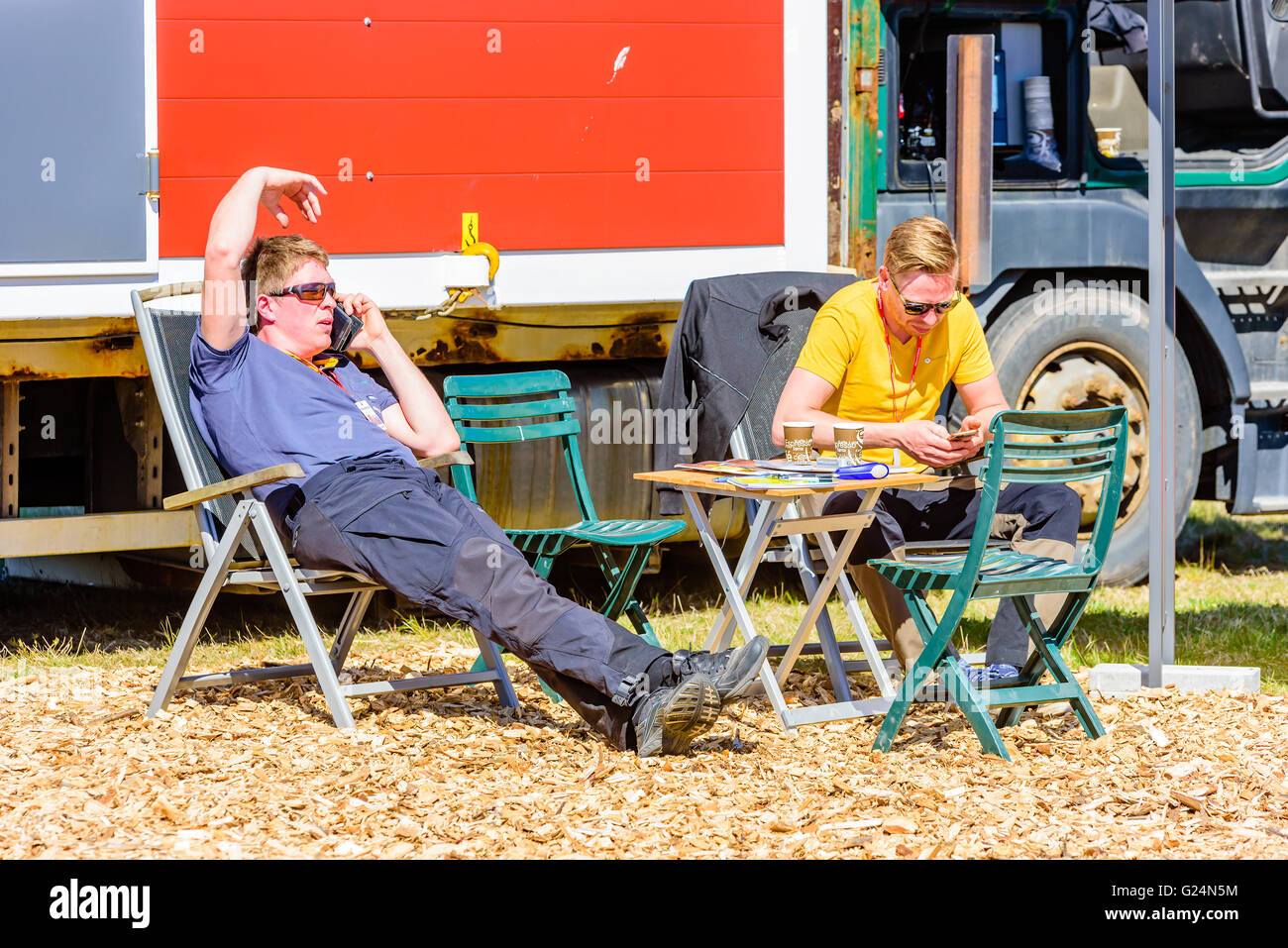 Emmaboda, Schweden - 13. Mai 2016: Wald und Traktor (Skog och Traktor). Zwei Männer, die auf Stühlen neben einem kleinen Tisch in t Stockfoto
