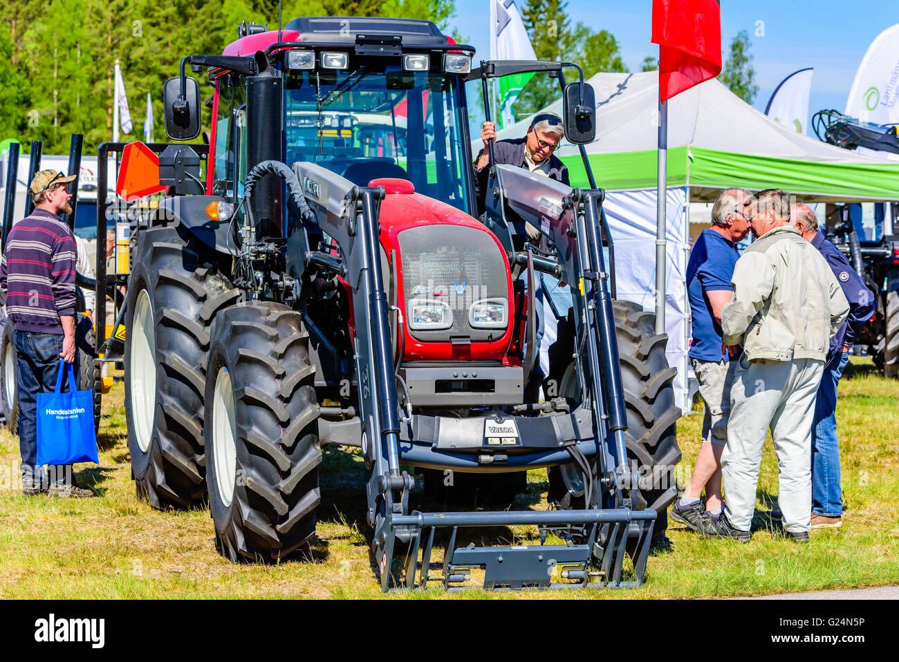 Emmaboda, Schweden - 13. Mai 2016: Wald und Traktor (Skog och Traktor). Besucher, die an einer roten Valtra A83 Traktor. Stockfoto