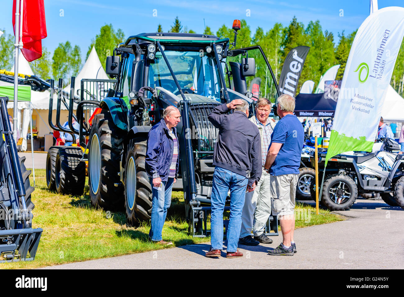 Emmaboda, Schweden - 13. Mai 2016: Wald und Traktor (Skog Och Traktor) fair. Besucher im Gespräch vor einem grünen Valtra N114 tr Stockfoto