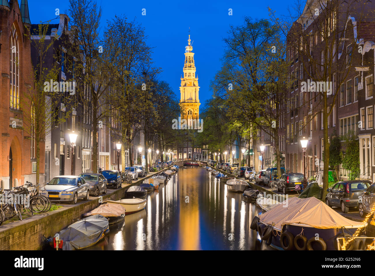 Zuiderkerk Kirchturm am Ende eines Kanals in der Stadt Amsterdam, die Niederlande in der Nacht. Stockfoto