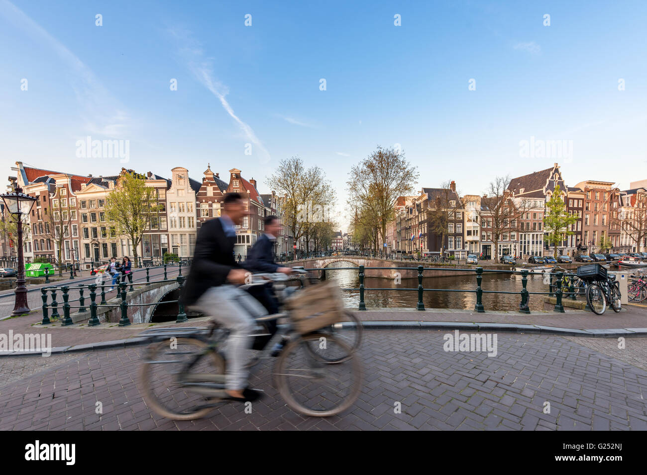 Menschen, die Radfahren durch Straßen der Stadt an einem schönen Sommertag in Amsterdam, Niederlande Stockfoto