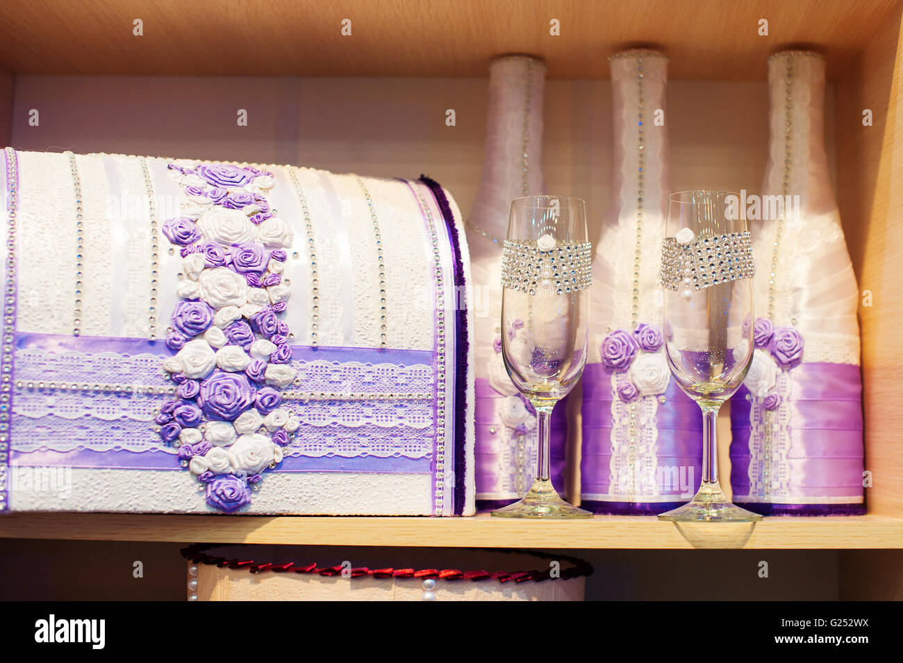 Glas Champagner und eine Box für Geld für die Hochzeit in lila Tönen Stockfoto