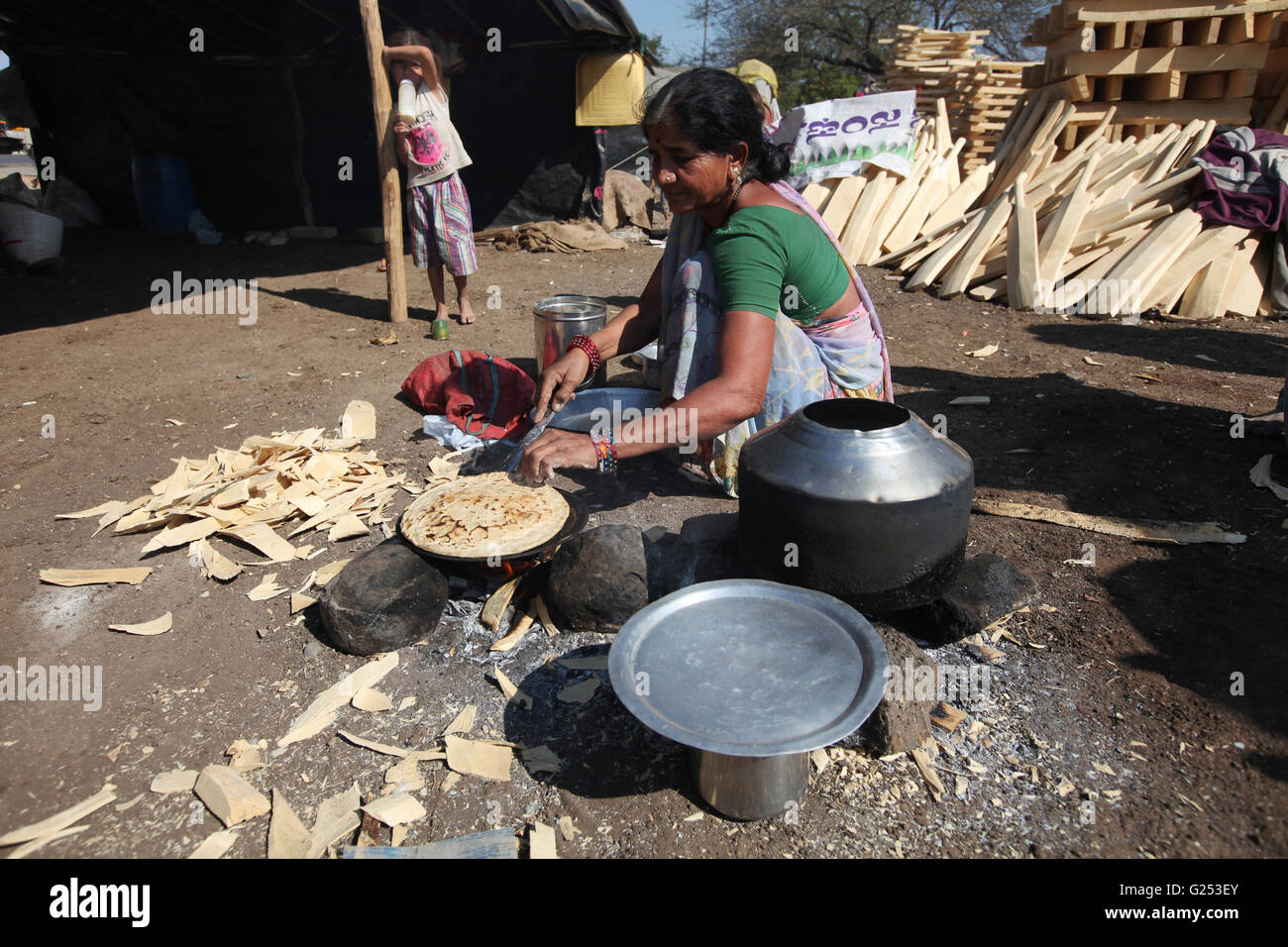 Frau macht Rotis / Weizen Roti sitzen am Straßenrand in Kamathi Dorf, Nanded Bezirk, Maharashtra, Indien Stockfoto