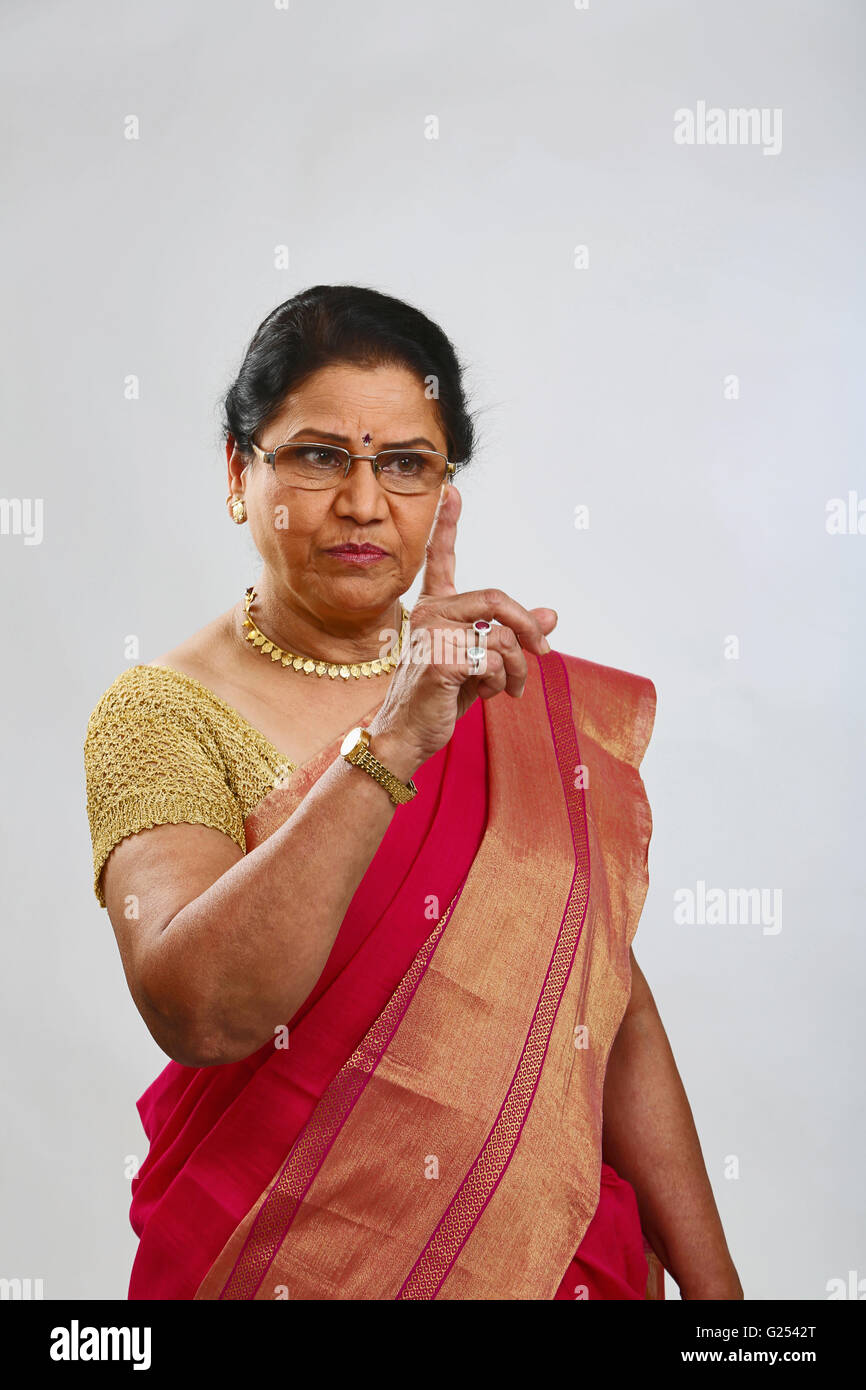 Frau mit Zeigefinger oben und strengen Blick. Stockfoto