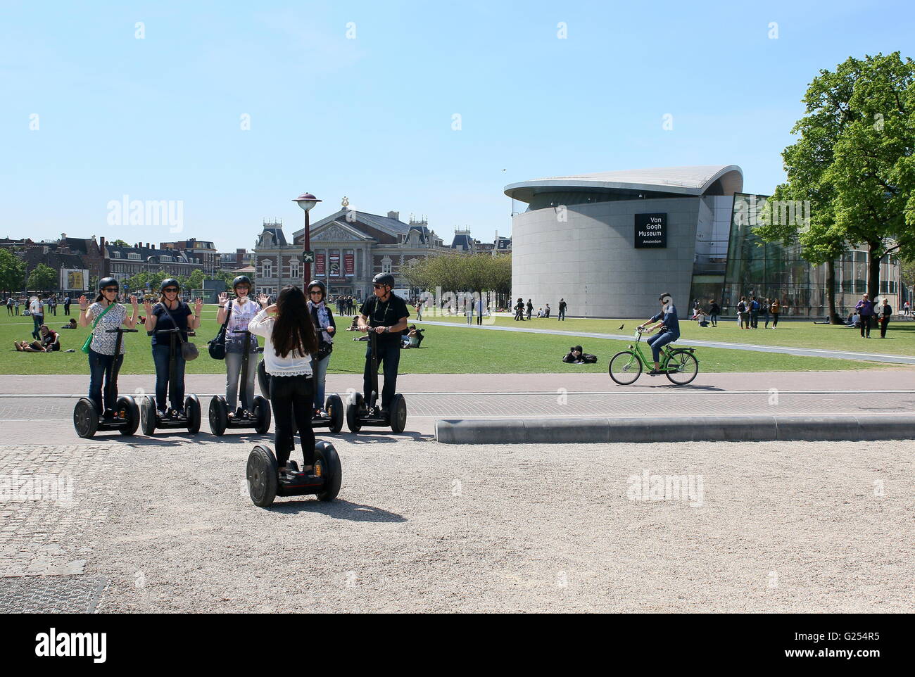 Touristen auf Segways am Museumplein (Museumsplatz), Amsterdam, Niederlande im Hintergrund das Konzert Halle & Van Gogh Museum. Stockfoto