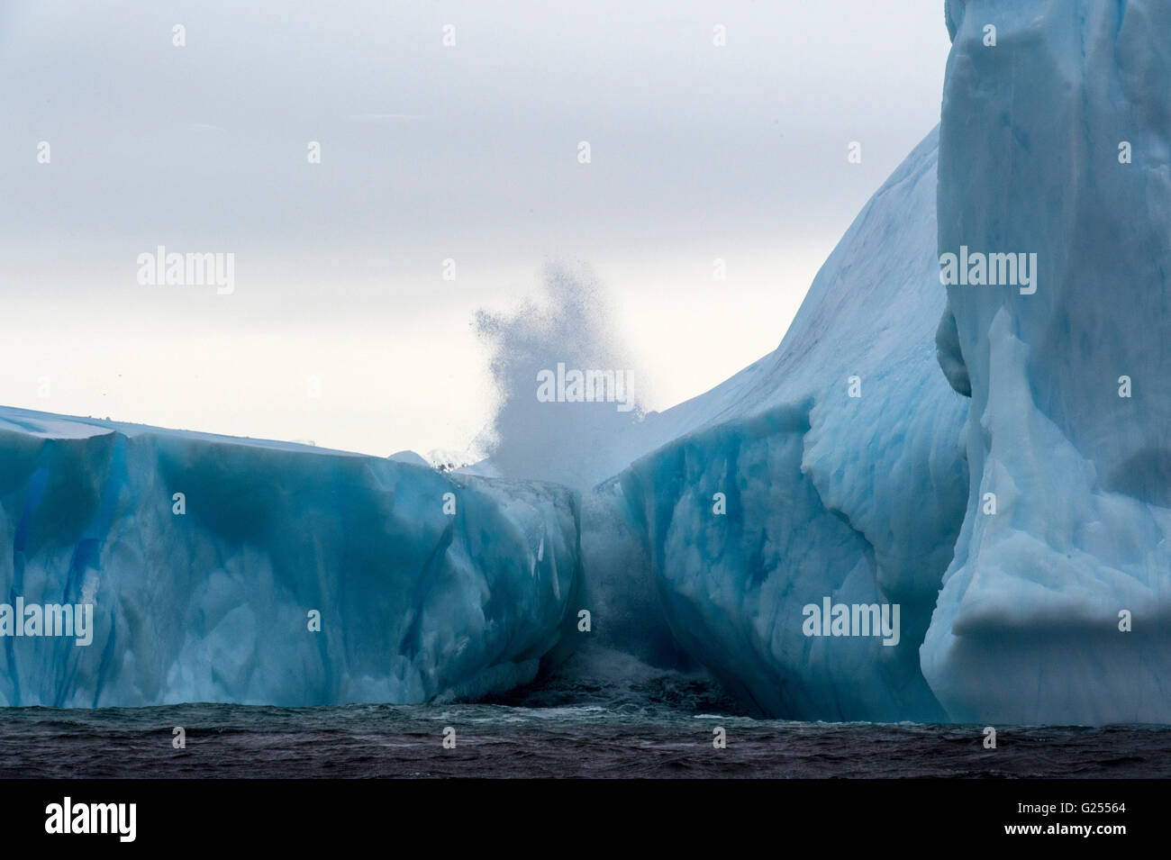 Eisberg mit Welle stürzt Melchior Inseln, Antarktis Stockfoto