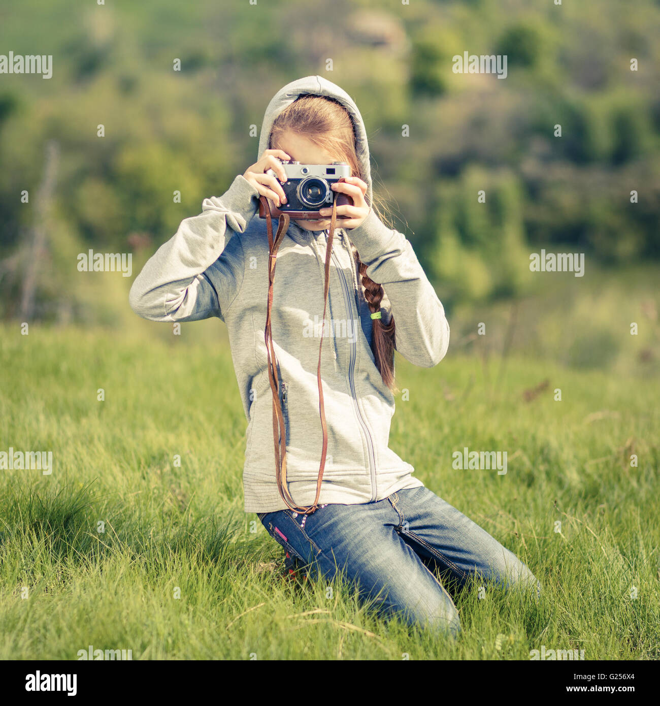 Kleinen Teenager-Mädchen nehmen Foto mit alten Kamera im Freien. Teenager Mädchen lernen Fotografie mit Retro-Film-Kamera Stockfoto