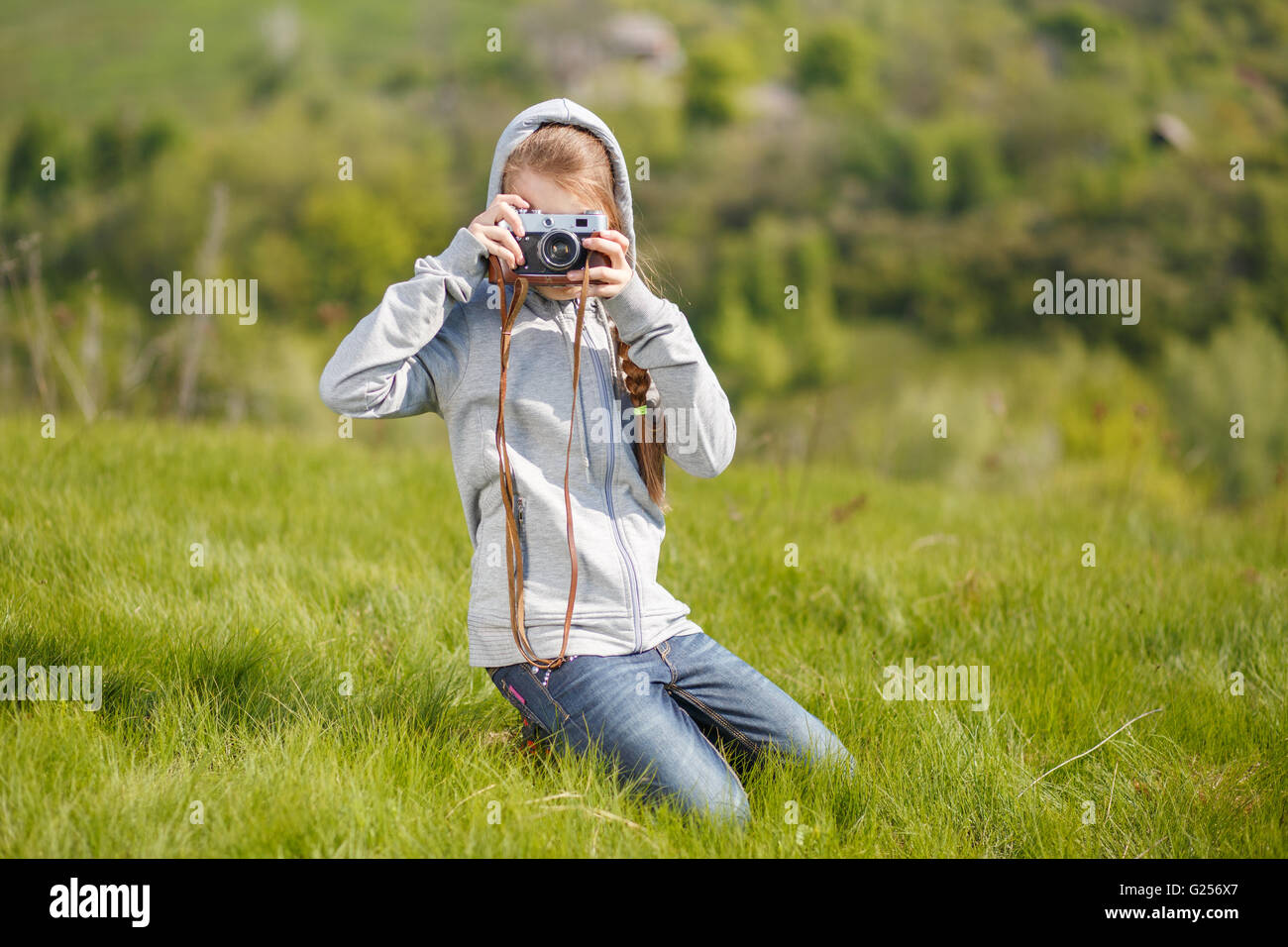 Kleinen Teenager-Mädchen nehmen Foto mit alten Kamera im Freien. Teenager Mädchen lernen Fotografie mit Retro-Film-Kamera Stockfoto