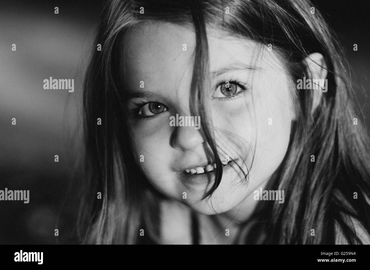Porträt eines lächelnden Mädchens mit strubbeligem Haar bedeckte Gesicht Stockfoto