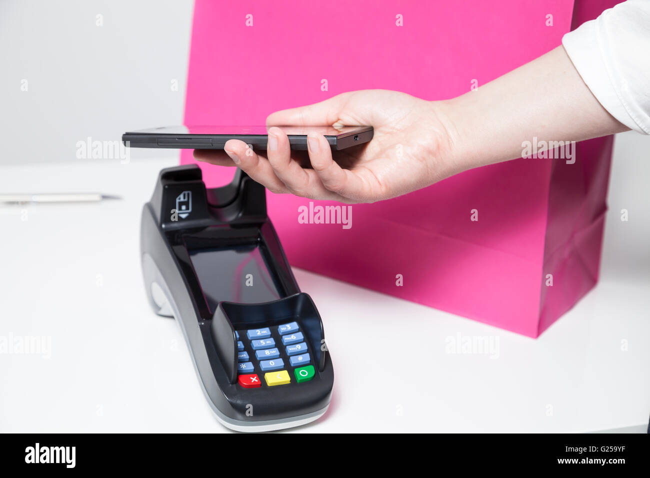 Frau mit Smartphone (mobile-Payment) in einem Geschäft zu bezahlen Stockfoto