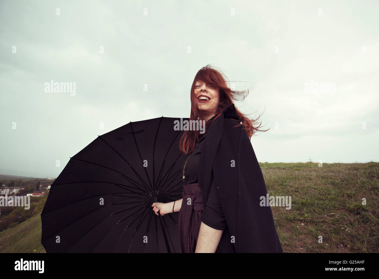 Frau mit Regenschirm im wind Stockfoto