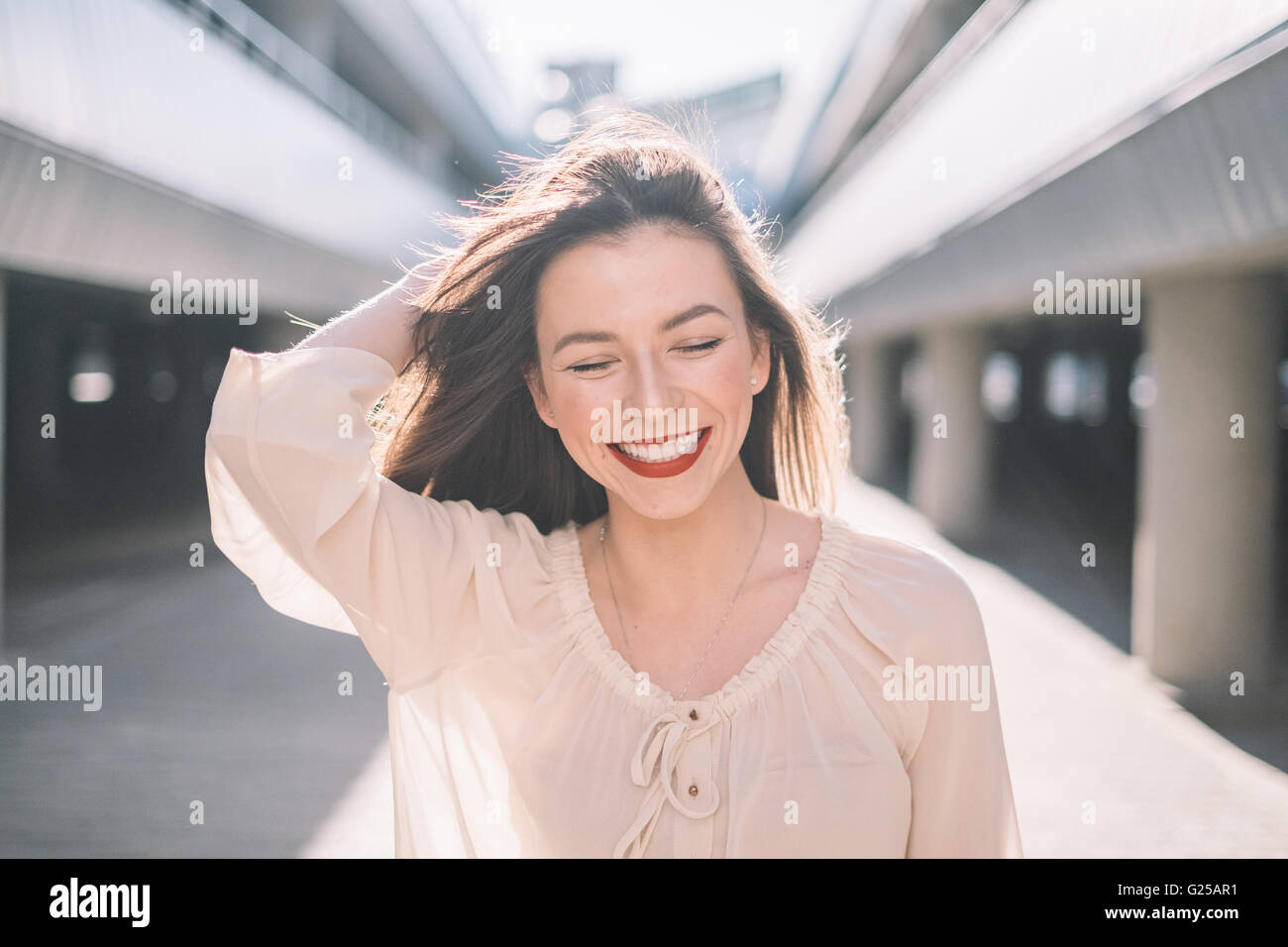 Porträt einer lächelnden Frau mit Haaren im Wind wehen Stockfoto