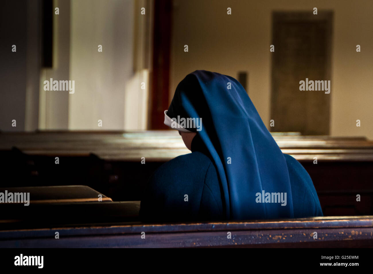 Nonne, die sitzen in der Kirche beten Stockfoto