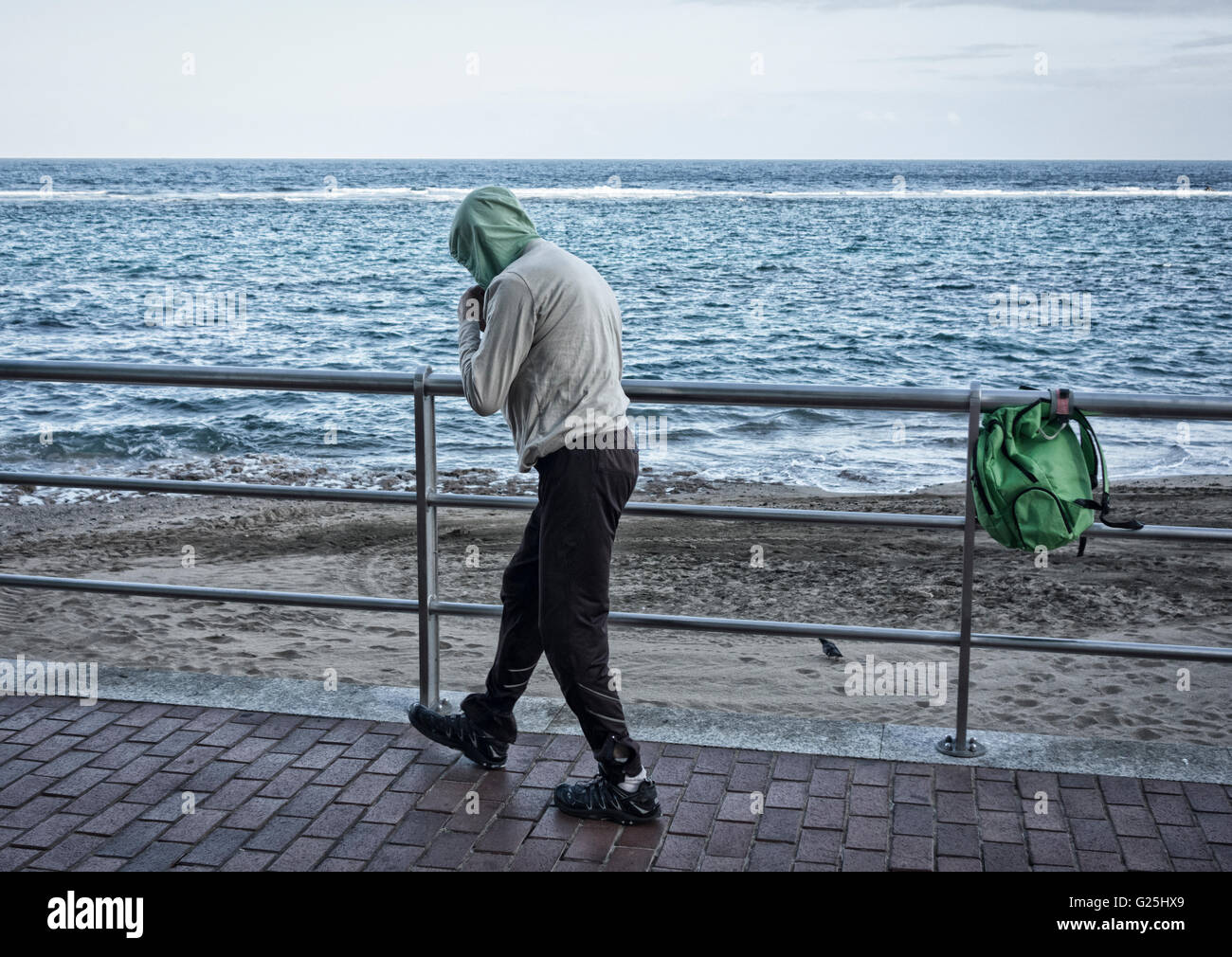 Mann trägt Hoodie Schattenboxen mit Blick auf Meer Stockfoto