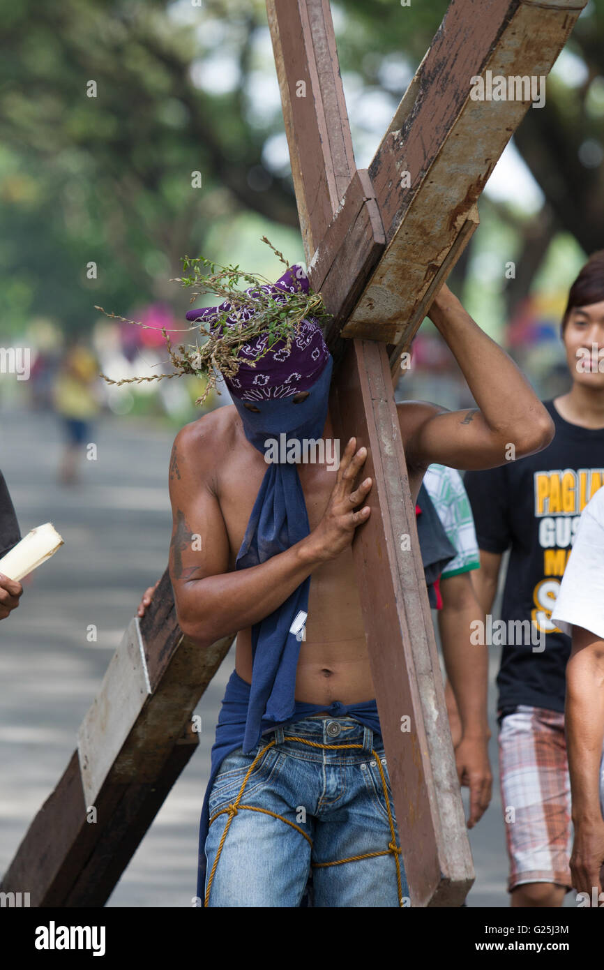 Ein Flagellanten trägt ein hölzernes Kreuz am Gründonnerstag, Teilnahme an der Verhandlung der Karwoche, Pampanga, Philippinen Stockfoto