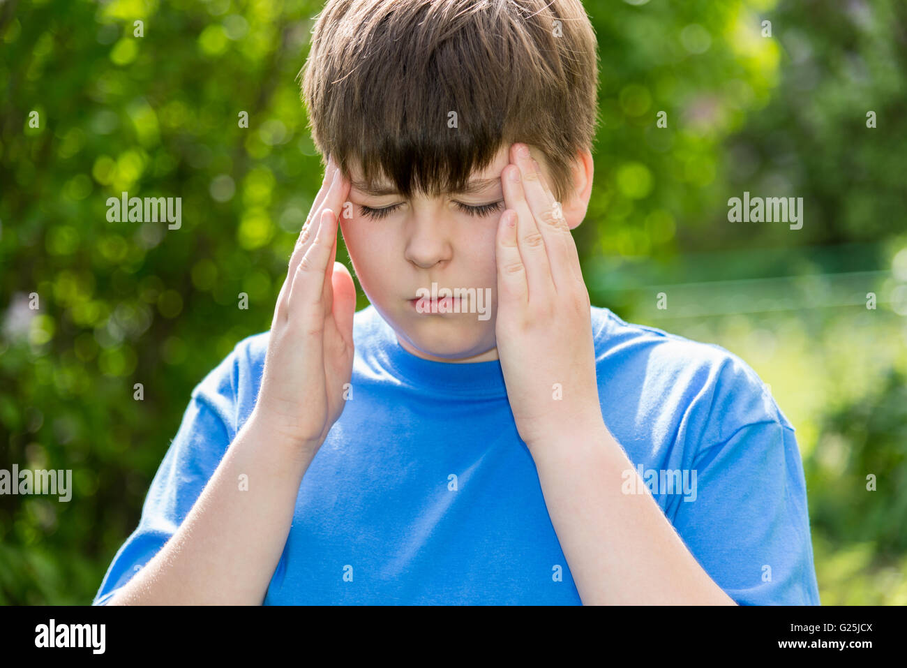 Junge Teenager mit Kopfschmerzen auf Natur Stockfoto