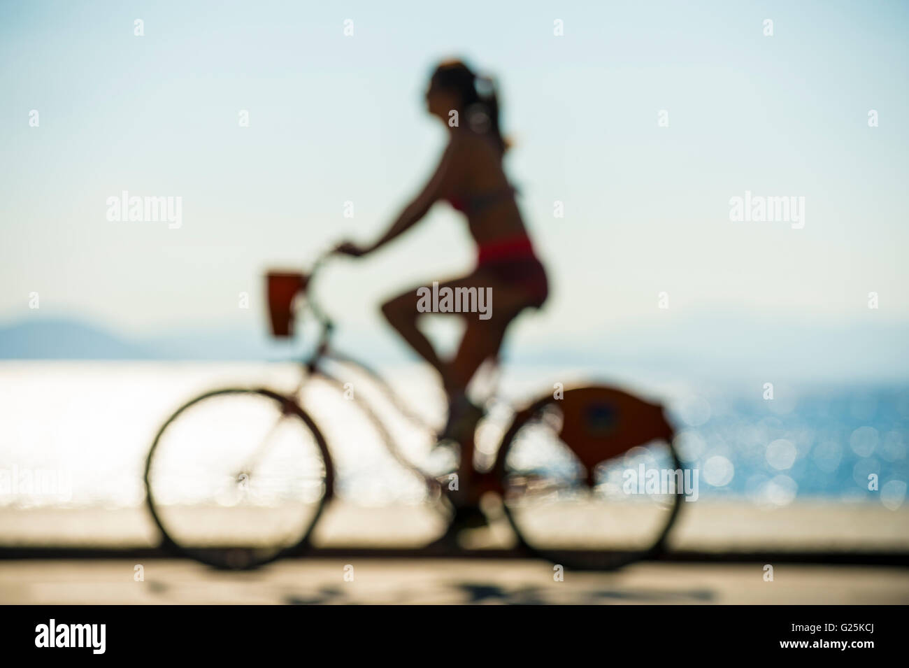 Defocus Silhouette der Frau Reiten Fahrrad auf der Promenade am Meer in Rio De Janeiro, Brasilien Stockfoto