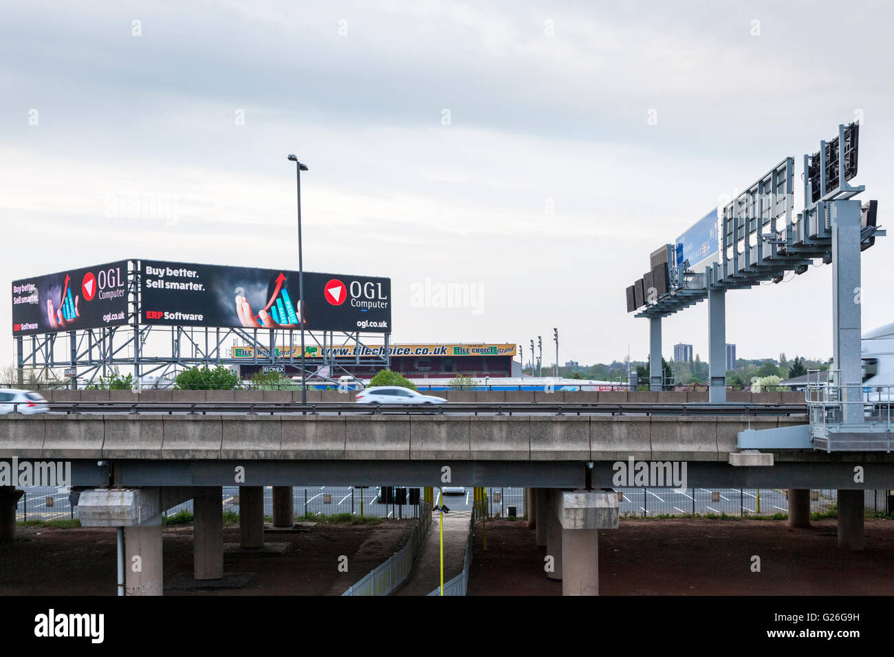 Angehobener Abschnitt der Autobahn M6 mit Gantry und hohe elektronische Werbung Anschlagtafel in der Dämmerung, Bescot, Walsall, West Midlands, England, Großbritannien Stockfoto