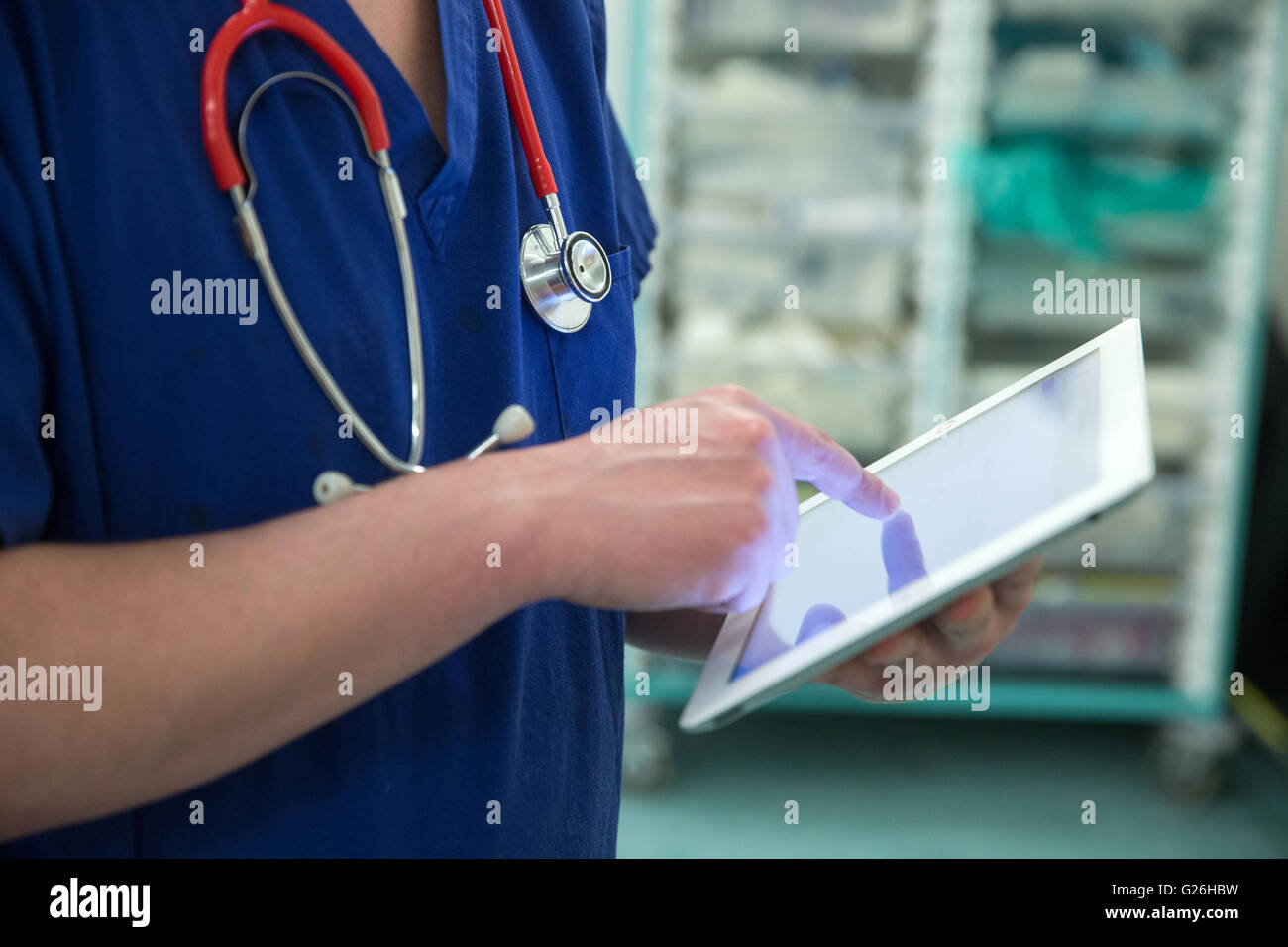 Ein Chirurg verwendet eine Ipad Patienten Details prüfen Stockfoto