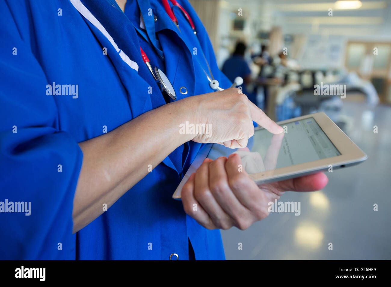 Eine Krankenschwester Check Patientendaten auf ihrem Ipad Stockfoto