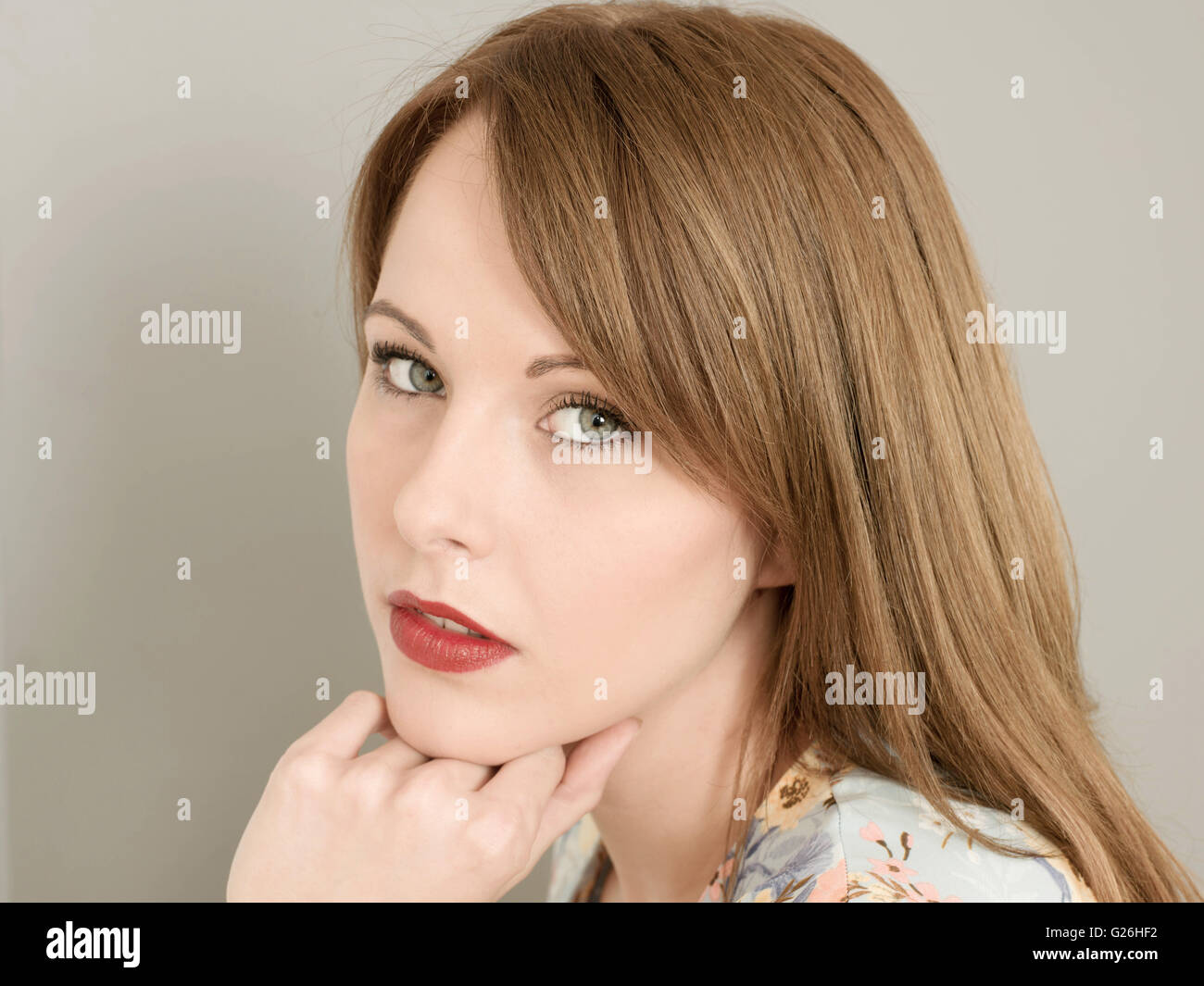 Porträt einer nachdenklichen betroffenen besorgt junge Frau schaut in die Kamera ruht der Kopf am Kinn Stockfoto