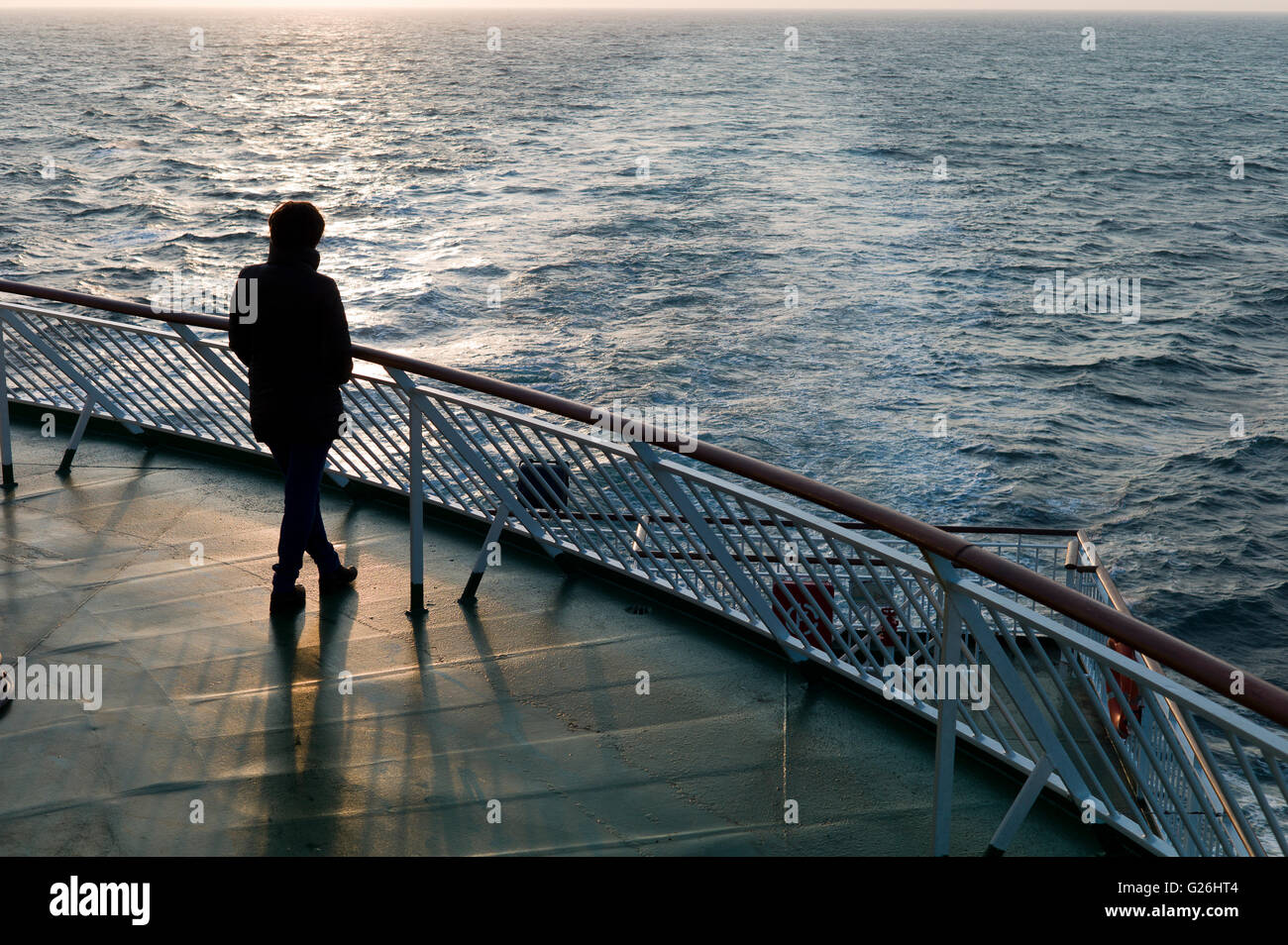 Einsame Frau in der Silhouette am Heck des Cross-Channel-Fähre bei Sonnenuntergang Stockfoto