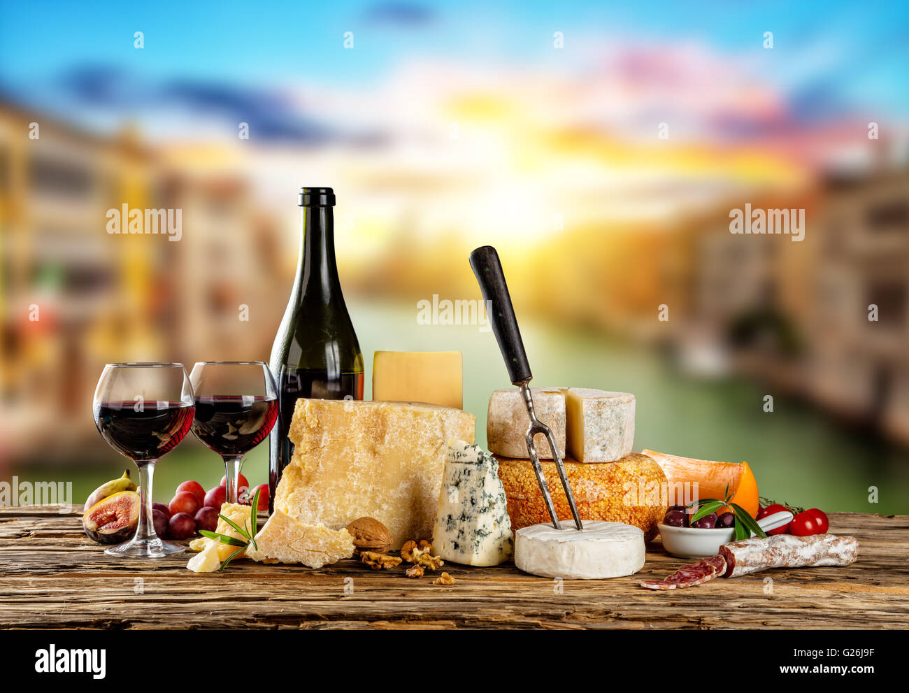 Verschiedene Arten von Käse, Gläser und eine Flasche Rotwein auf Holztisch, Exemplar für Text gelegt. Altstadt auf Hintergrund Unschärfe Stockfoto