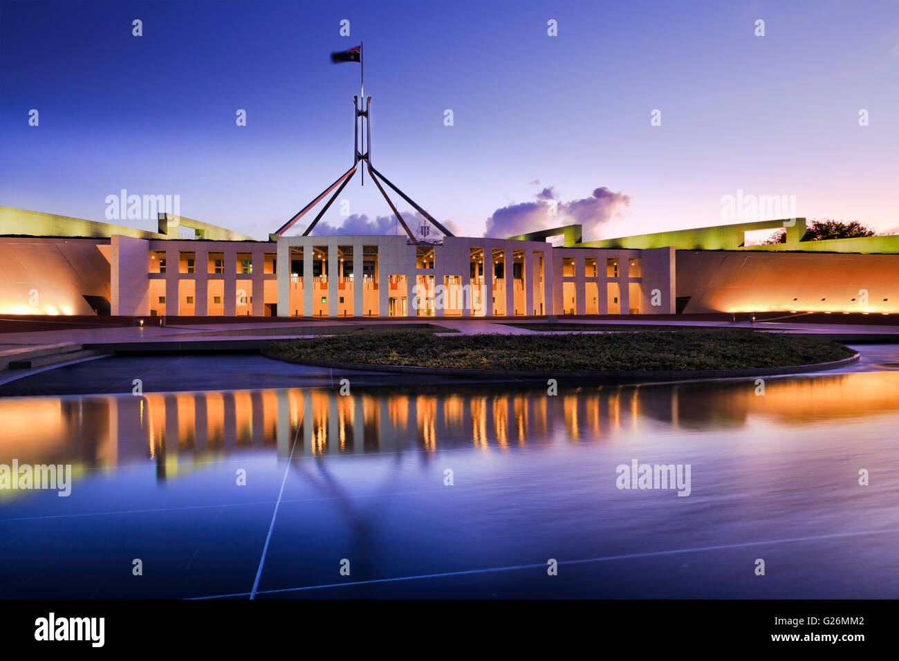 Australische nationale Parlamentsgebäude in Canberra. Fassade der Buidling hell erleuchtet und reflektiert in fließend Wasser Stockfoto