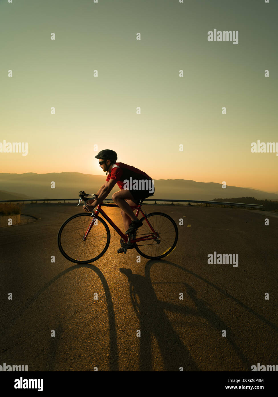 Radfahrer auf Rennrad in Bewegung bei Sonnenuntergang Stockfoto