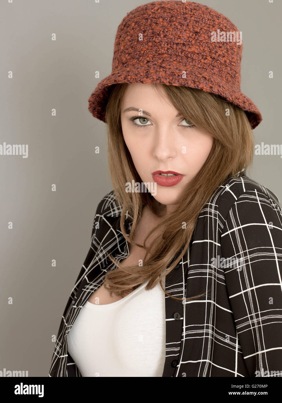 Porträt einer traurig unglücklich Frau trägt eine rote Wollmütze und ein lässig kariertes Hemd Stockfoto