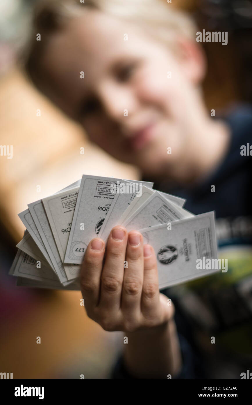 Ein 8 Jahre alter Junge zeigt seine Panini Fußball-Sammelkarten vor in seinem Aufkleber Sammlung Sammelalbum einfügen. Stockfoto