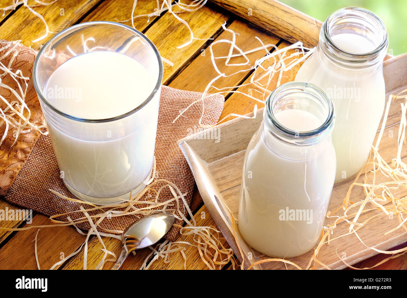 Glas Milch auf einem Tisch mit zwei Flaschen Milch Draufsicht auf das Feld Stockfoto