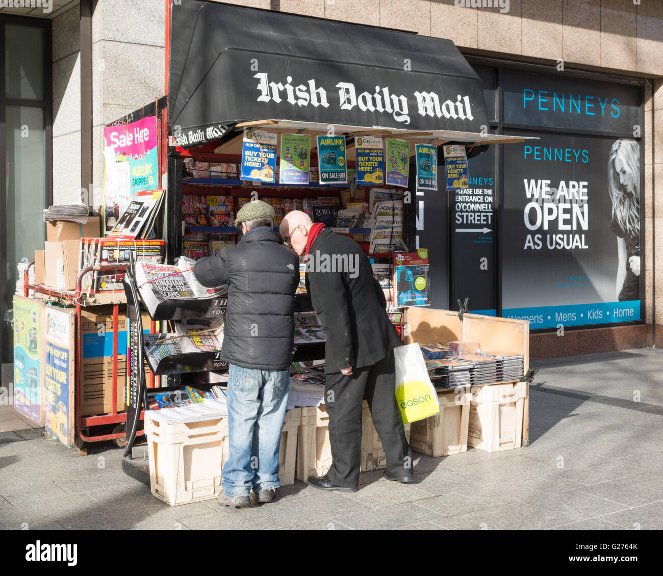 Kunde kauft eine Zeitung vom Zeitungskiosk stall auf O'Connell Street, Dublin, Irland Stockfoto