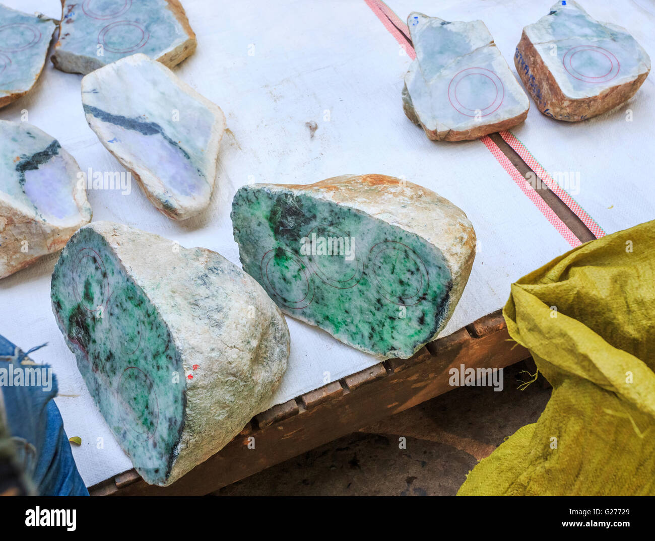 Blöcke von grob geschnitten jade für Verkauf in einem Stall auf dem Jademarkt, Mandalay, Myanmar (Burma) Stockfoto