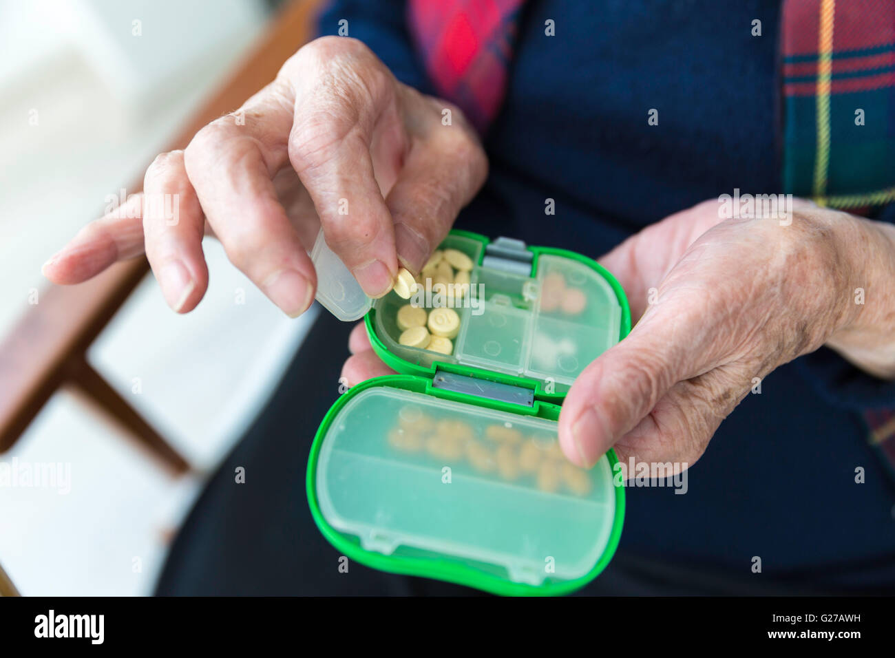 Türkische Seniorin Pillen aus grün gefärbten Medizin-Box-Detailansicht Stockfoto