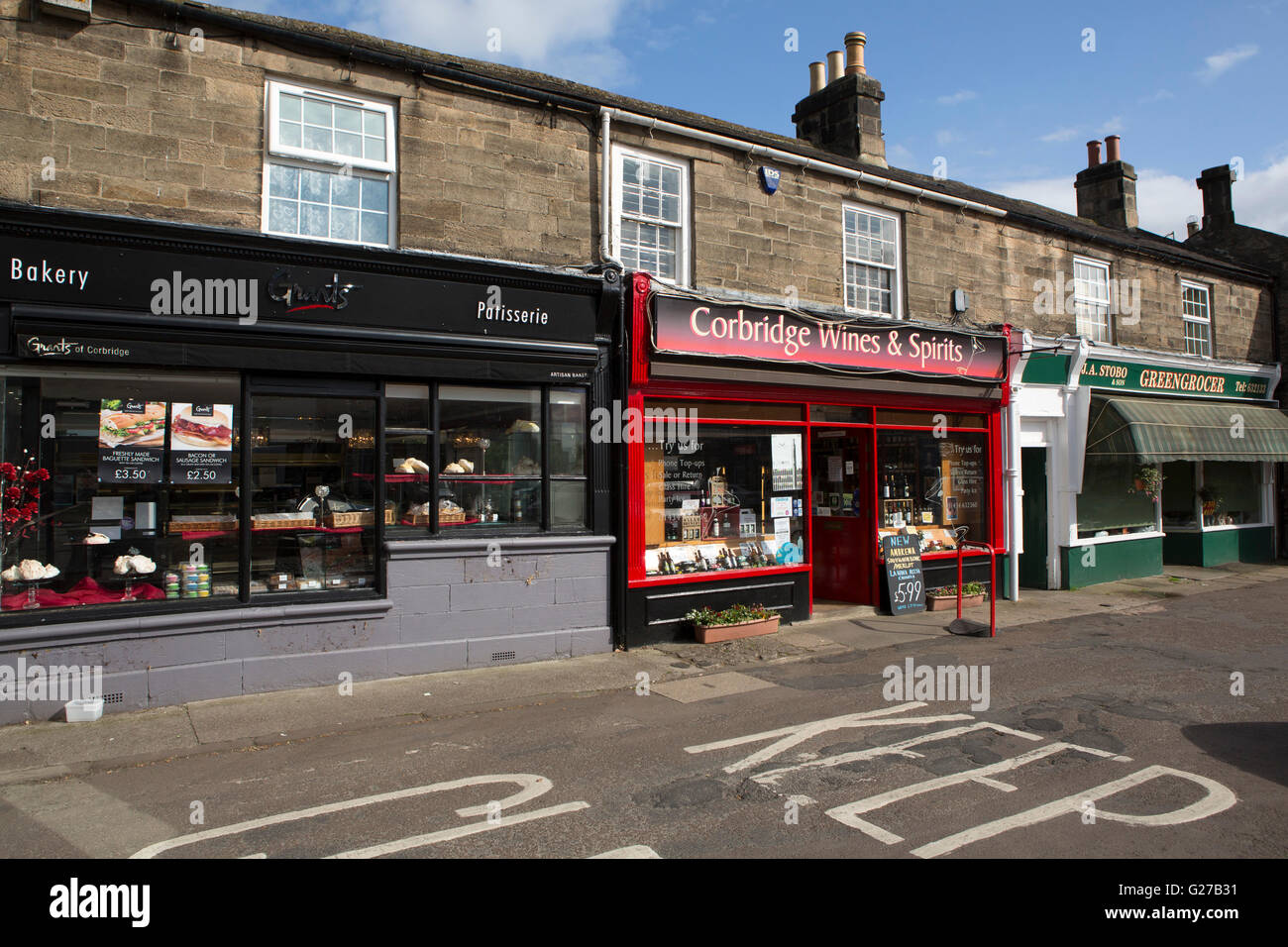 Eine Bäckerei, ein Spirituosengeschäft und ein Gemüsehändler Shop in Corbridge, England. Die Stadt liegt im nördlichsten Landkreis des Landes, Stockfoto