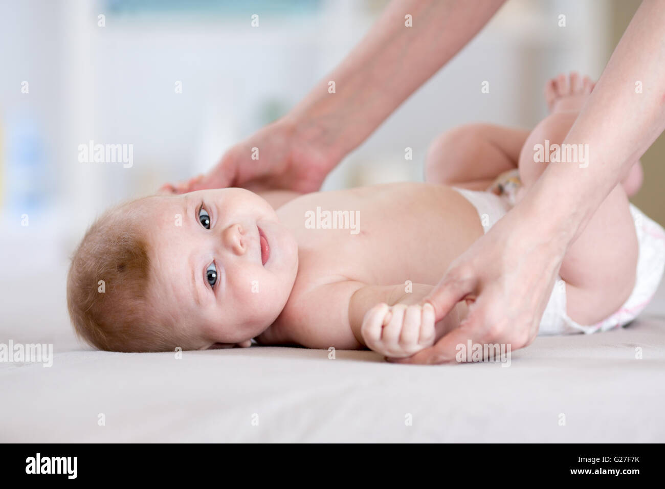 Baby-Massage. Mutter macht Gymnastik Kind Stockfoto