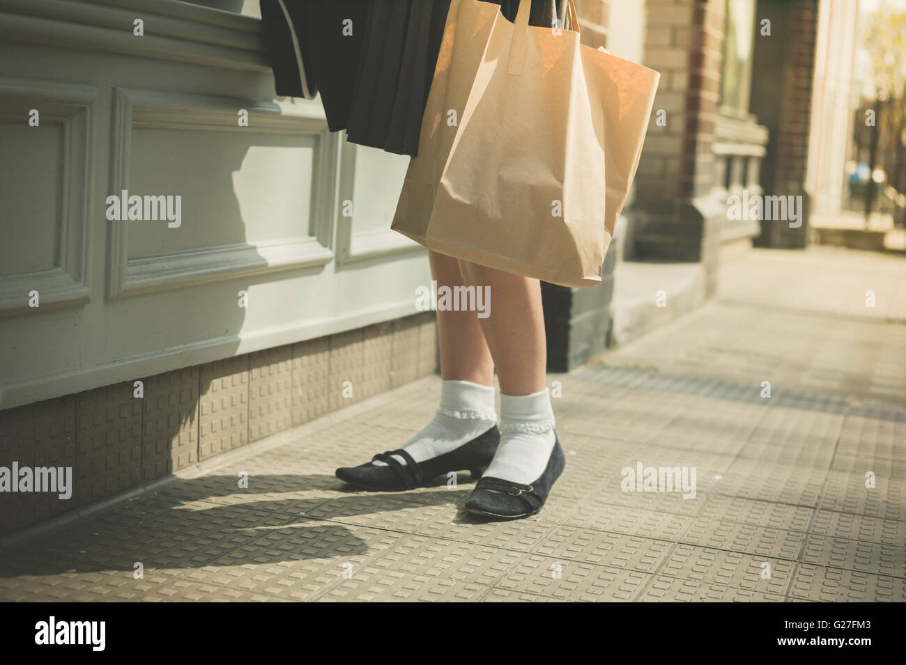 Eine junge Frau trägt einen Rock auf der Straße an einem sonnigen Tag Fuß Stockfoto