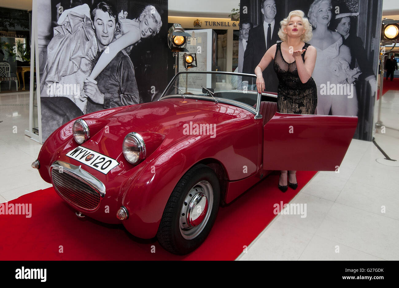 Offiziellen Marilyn Monroe Lookalike Suzie Kennedy posiert auf einem Oldtimer, das Vermächtnis einer Legende-Ausstellung im Design Centre in London zu starten. Stockfoto