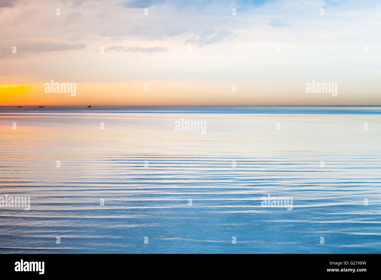 Noch blaue Meerwasser unter bewölktem Himmel bunten Abend Stockfoto
