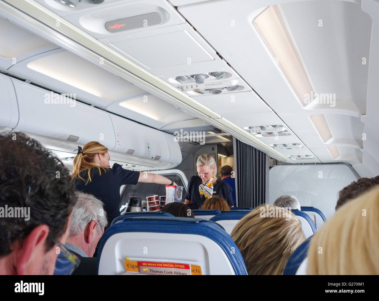 Flugbegleiterinnen, die Speisen und Getränke an Bord einer Thomas Cook Airlines Airbus A321 Flugzeug Stockfoto