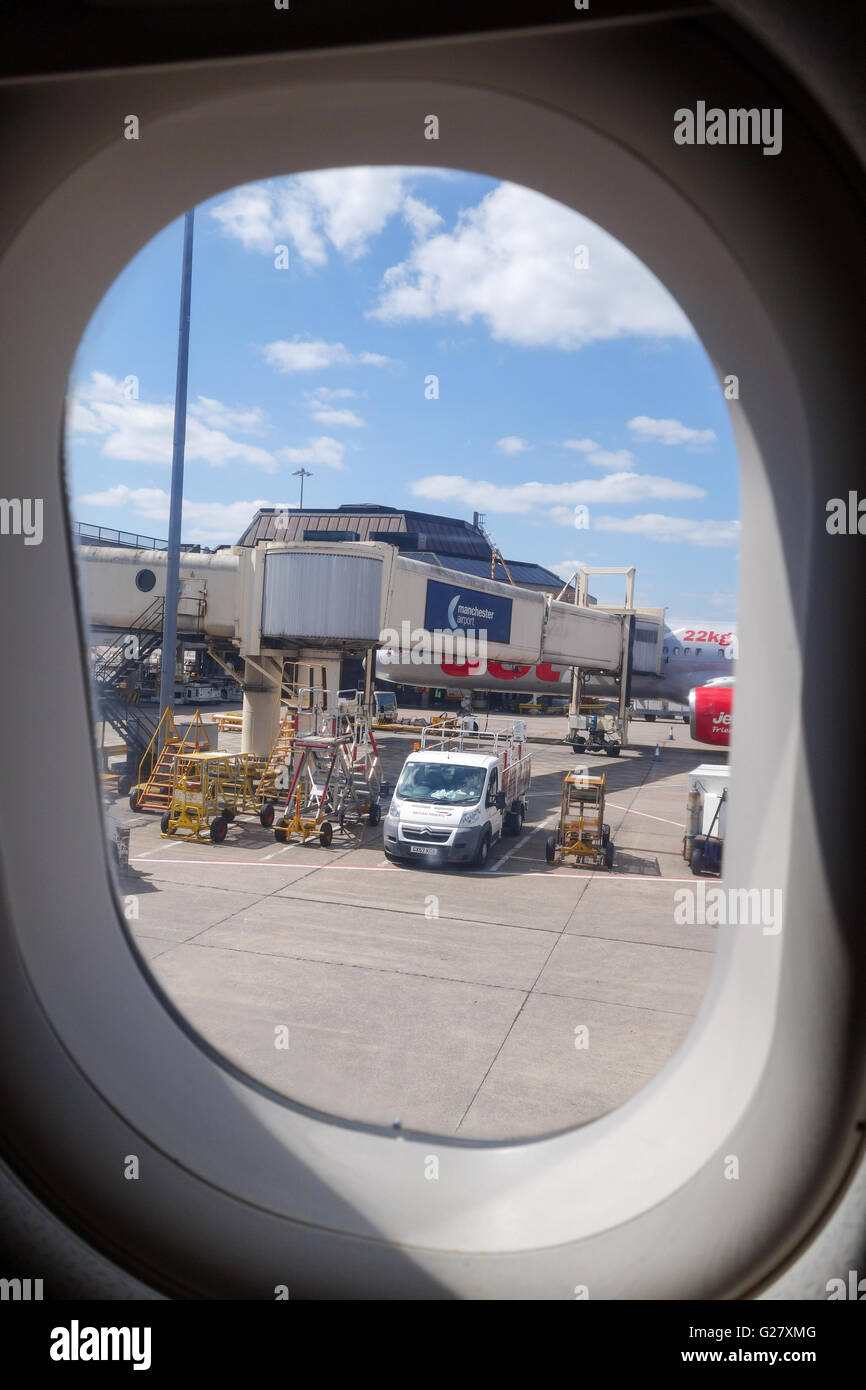 Blick durch ein Flugzeug Fenster an einer Fluggastbrücke oder boarding Fluggastbrücke bei Manchester Flughafen England UK Stockfoto