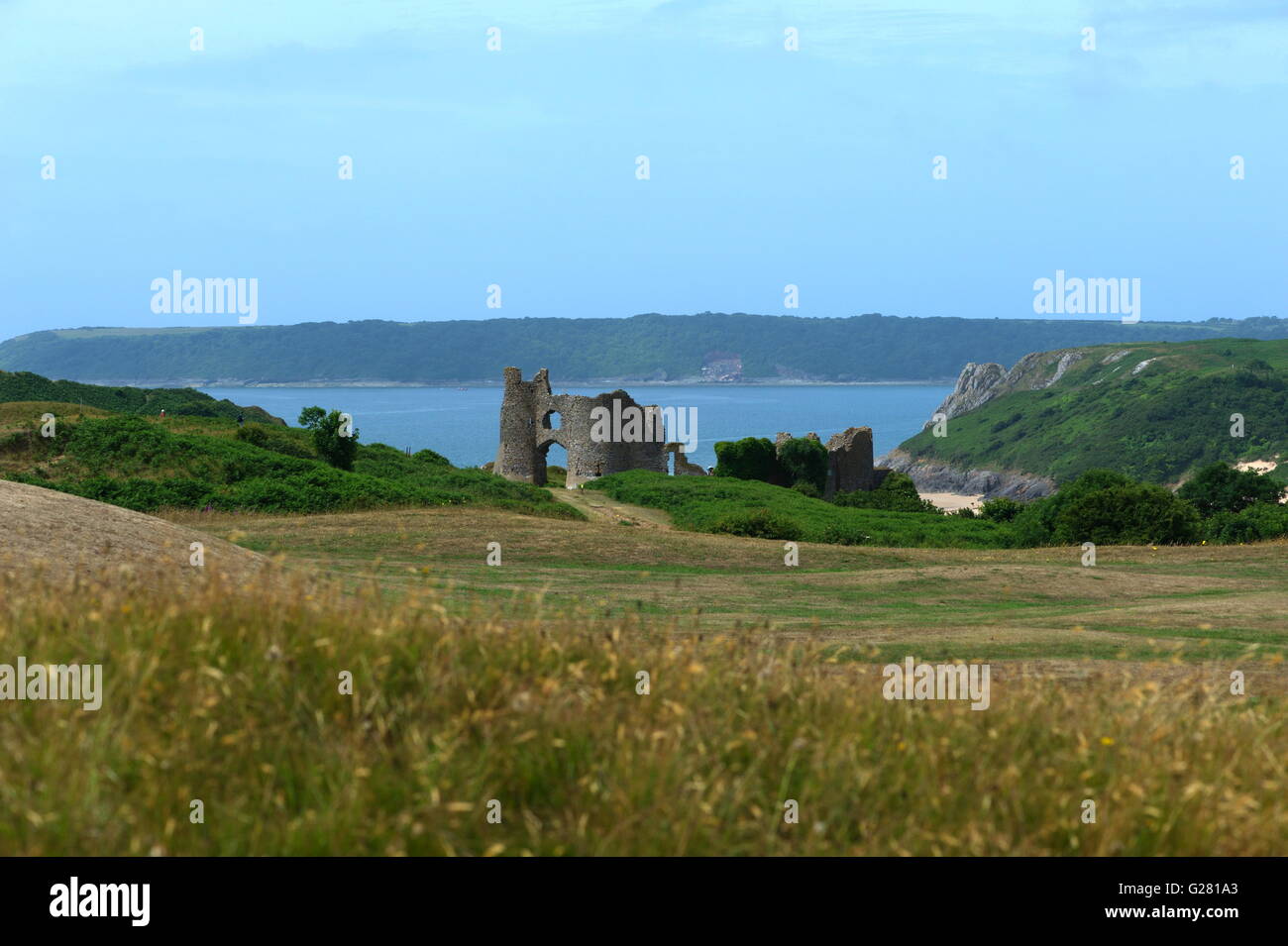 Überreste der normannischen Burgmauern sind Hghlighted gegen das blaue Meer und den Himmel von drei Cliifs und Oxwich Buchten Stockfoto