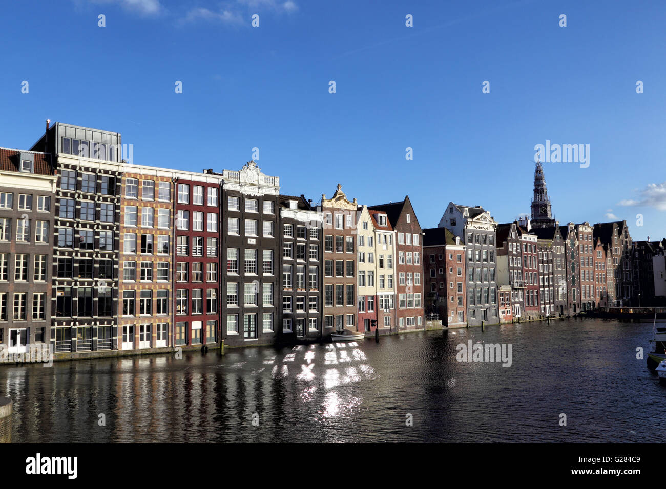 Typische Amsterdamer Häuser stehen direkt am Kanal am Damrak in Amsterdam, Niederlande, Europa. Stockfoto