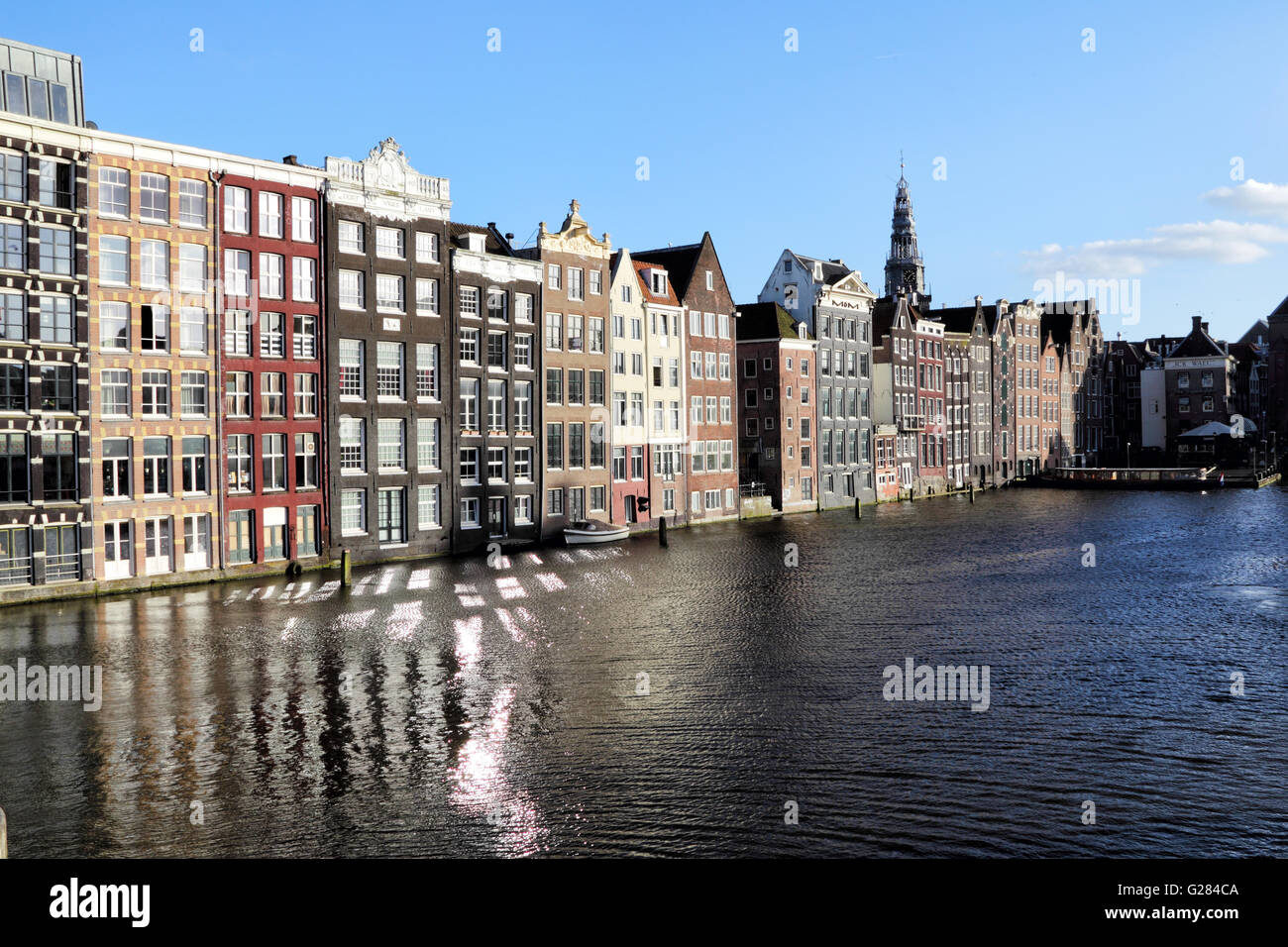 Typische Amsterdamer Häuser stehen direkt am Kanal am Damrak in Amsterdam, Niederlande, Europa. Stockfoto